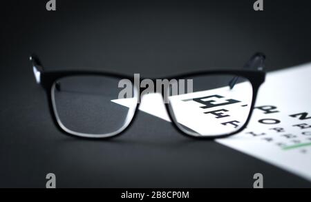 Tableau des lettres de test des lunettes sur la table de l'opticien. Clinique d'ophtalmologie ou d'optométrie. Mise au point à travers l'objectif. Examen de la vue. Banque D'Images