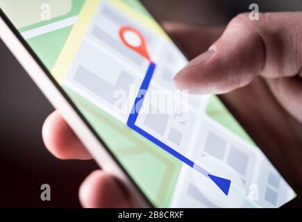 Application de carte dans le smartphone. Homme naviguant en ville avec un téléphone portable. Personne utilisant le téléphone portable et recherchant un hôtel avec l'application de navigation. Banque D'Images
