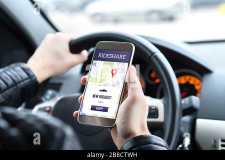 Pilote de partage de trajets en voiture à l'aide de l'application de partage de trajets sur téléphone mobile. Nouvelle demande de trajet en taxi du client dans l'application smartphone. Banque D'Images