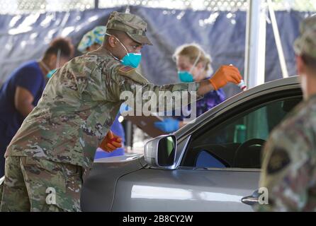 Pembroke Pines, États-Unis. 21 mars 2020. Les membres de la Garde nationale de Floride marquent les véhicules à tester au centre de tests mobiles COVID-19 situé à C.B. Smith Park le 20 mars 2020 à Pembroke Pines, en Floride. Crédit: Michael Baltz/Planetpix/Alay Live News crédit: Planetpix/Alay Live News Banque D'Images