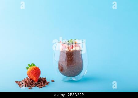 Pudding au chocolat, décoré de fraises sur fond bleu Banque D'Images