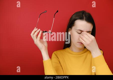 Femme malheureuse prenant des lunettes fatiguées massante touchant le pont de nez, fille épuisée souffrant de maux de tête, sensation de douleur, respiration, calmant Banque D'Images