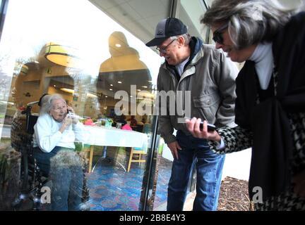 Ballwin, États-Unis. 21 mars 2020. Wilma Grove utilise un téléphone portable pour parler à ses enfants, Judy Kekich et Ed Grove lors de leur visite aux jardins Delmar sur les verts à Ballwin, Missouri, le 21 mars 2020. La famille a été forcée de rendre visite à sa mère de 100 ans chaque jour de l'extérieur en raison des préoccupations de Coronavirus. Les cas connus du Missouri de COVID-19, est à 73 y compris trois morts.photo par Bill Greenblatt/UPI crédit: UPI/Alay Live News Banque D'Images