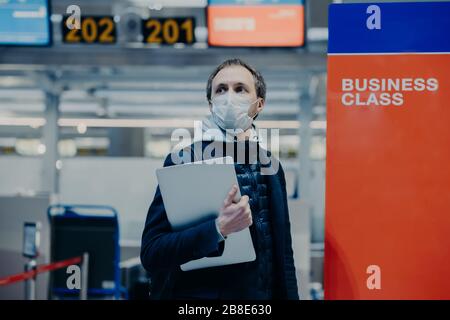 Les poses touristiques à l'aéroport, veut rentrer à la maison pendant la quarantaine et la pandémie mondiale, porte un masque médical protecteur contre le coronavirus, évite l'infecti Banque D'Images