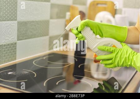 Gros plan de femme à la main nettoyage de la surface électrique moderne en céramique de verre de cuisson avec éponge et détergent Banque D'Images