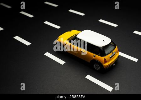 Izmir, Turquie - 28 juillet 2019. Vue supérieure d'une mini-voiture jaune Cooper S Toy sur une route asphaltée avec voies de circulation. Banque D'Images