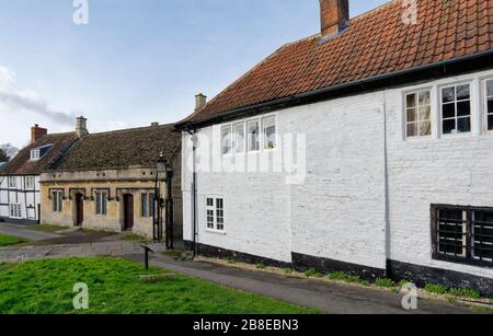 Maison du XVIe siècle et maisonnettes du XIXe siècle dans le cimetière de St John's avec portes de Churchyard de fer, Devizes, Wiltshie, Royaume-Uni Banque D'Images