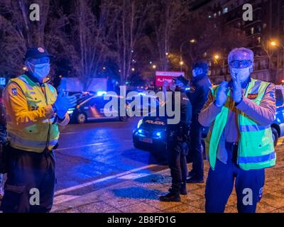 Deux ambulanciers paramédicaux d'urgence se clatent les mains pour montrer leur soutien aux travailleurs des soins de santé hospitaliers qui luttent contre la pandémie de coronavirus. Tous les jours, à 20:00, des paramédicaux et plusieurs patrouilles de police se réunissent à l'entrée principale de l'hôpital Fundación Jiménez Díaz au centre-ville de Madrid. Les paramédicaux et les policiers applaudissent, allument leurs feux de voiture et sonnent leurs sirènes pendant quelques minutes pour rendre hommage aux médecins et aux infirmières. Banque D'Images