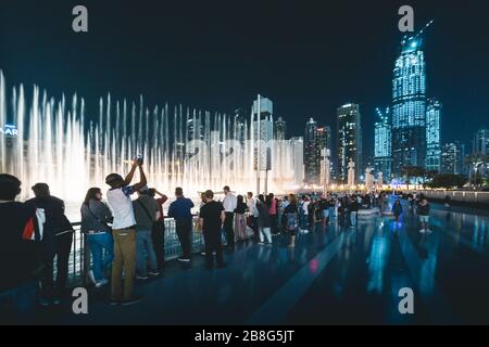 Piétons à la fontaine de Dubaï la nuit Dubaï - Émirats arabes Unis Banque D'Images