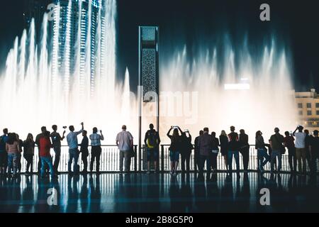 Piétons à la fontaine de Dubaï la nuit Dubaï - Émirats arabes Unis Banque D'Images