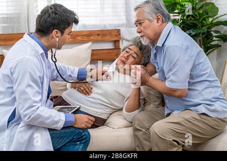 Gros plan Doctor Hand utilisant stéthoscope pour auscultate Asian grand-parent patient en maison, service assurance vie à la maison, soins de santé avec long live, PR Banque D'Images