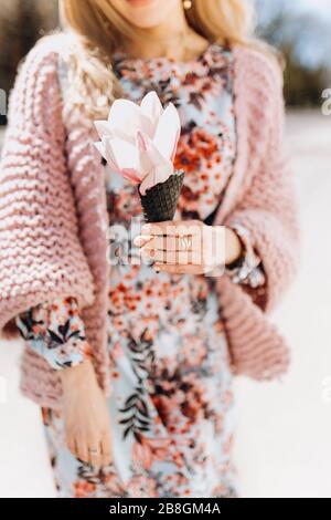 Grande belle fleur de magnolia dans les mains douces d'une fille. Un seul foyer. Banque D'Images