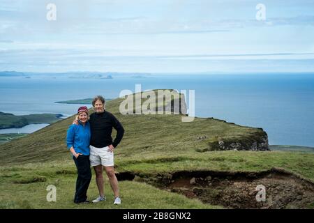 Un couple caucasien dans les années 50 se trouve sur la formation de glissements de terrain au sentier de randonnée de Quiraing, sur l'île de Skye, en Écosse, au Royaume-Uni, en Europe Banque D'Images