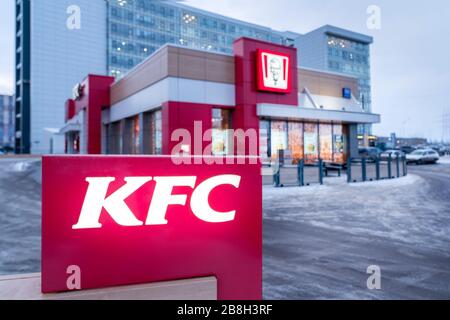 Krasnoyarsk, Russie, 20 mars 2020: Restaurant KFC, vue sur le bâtiment de l'extérieur et un panneau publicitaire brûlant. Hiver. Banque D'Images