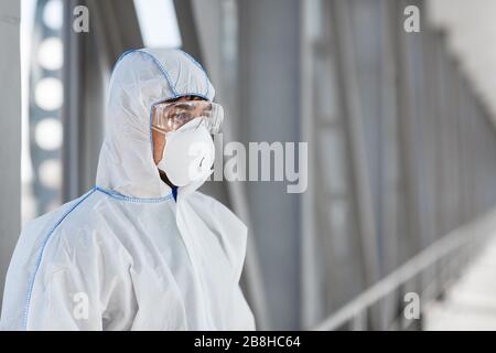 Homme portant un costume et un masque biologiques de protection en raison du coronavirus Banque D'Images