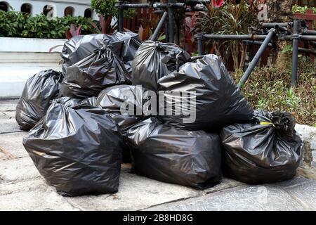 déchets tas de déchets sacs noirs pile plastique sur le sol du parc public, beaucoup de déchets noirs déchets sacs plastique pile Banque D'Images