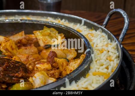 Dak Galbi, poulet frit épicé coréen avec sauce épicée aux légumes et à la Corée ou Gochujang dans une grande poêle chaude, au fromage Banque D'Images