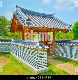 La porte en bois et la clôture en pierre du jardin traditionnel coréen de la Corée du Sud du parc Rajaruek, Chiang Mai, Thaïlande Banque D'Images