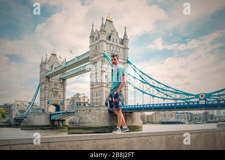 guy lors d'un voyage en ville à Londres, les hommes de youn au bord de l'eau au bord de la Tamise aux célèbres endroits de Londres, les hommes visitent Tower Bridge Banque D'Images