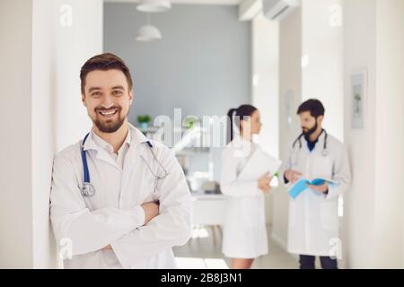 Un médecin pratiquant avec un stéthoscope sourit dans le contexte d'un médecin de la clinique. Banque D'Images