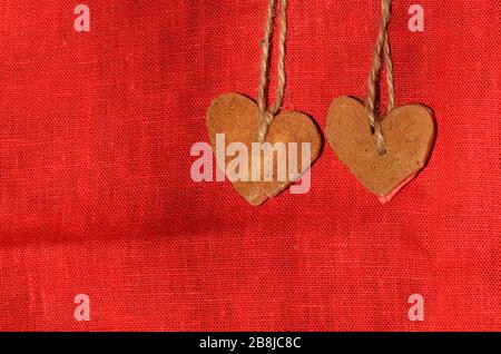 Cookies au cœur rose sur fond rouge. Biscuits colorés de Saint-Valentin en forme de coeur Banque D'Images