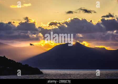 Coucher de soleil sur la mer Tyrrhénienne vue de Zafferano cap près de Santa Flavia sur l'île Sicile en Italie, vue avec Pellegrino montagne sur fond Banque D'Images