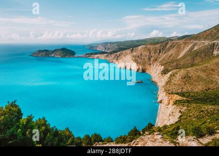 Côte ouest de Kefalonia. Ville du village d'Assos et péninsule de Frourio. Magnifique baie bleue avec roches calcaires brunes et nuages blancs à l'horizon. Grèce Banque D'Images