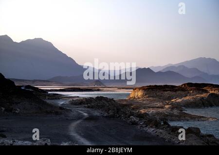 Afrique, Djibouti, lac Assal. Vue sur le paysage du lac Assal avec des montagnes en arrière-plan et une route en premier plan à gauche. Banque D'Images