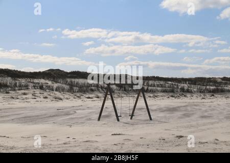 Norderney, Allemagne. 22 mars 2020. Une balançoire abandonnée sur une plage vide. Les unités de la police anti-émeute doivent renforcer leurs collègues de Norderney dans la suppression des hôtels et des appartements de vacances. Les invités de vacances doivent quitter l'île de Frise orientale dans la lutte contre la propagation du coronavirus. Crédit: Volker Bartels/dpa/Alay Live News Banque D'Images