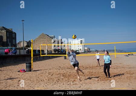 Portobello, Édimbourg, Écosse, Royaume-Uni. 22 mars 2020. Volley sur le sable. Soleil et ciel bleu avec une température tôt le matin de 2 degrés centigrade augmentant à 8 degrés d'ici midi. Une variété de personnes sur la plage se détendre et profiter des activités pour s'éloigner de la télévision et de la radio. Banque D'Images