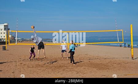 Portobello, Édimbourg, Écosse, Royaume-Uni. 22 mars 2020. Volley sur le sable. Soleil et ciel bleu avec une température tôt le matin de 2 degrés centigrade augmentant à 8 degrés d'ici midi. Une variété de personnes sur la plage se détendre et profiter des activités pour s'éloigner de la télévision et de la radio. Banque D'Images