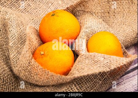 Tangerines mûres juteuses sur fond de tissu à l'homespun rugueux. Gros plan Banque D'Images