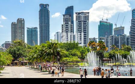 Bureaux et résidences tours et fontaines dans le lac Symphony et les touristes qui aiment passer une journée au parc KLCC Kuala Lumpur en Malaisie. Banque D'Images