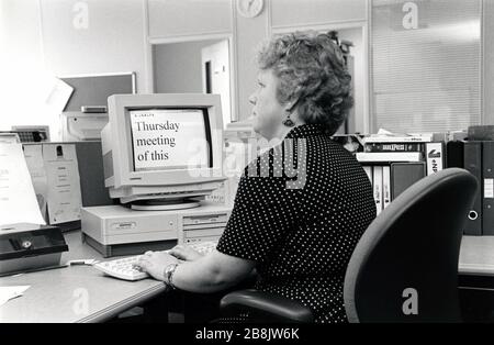 Femme malvoyante au travail utilisant un grand écran d'impression, Royaume-Uni années 1990 Banque D'Images