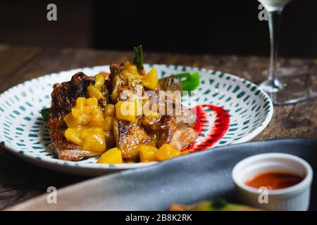 Poulet Mojito cuisse de poulet désossée braisée, réduction de rhum mouillée, salsa de mangue, tomates herbeuses et pommes de terre rôties Banque D'Images