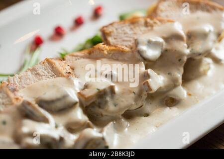 Poulet sur gnocchi râpé dans la sauce crème de champignons et de fromage fumé sur la table Banque D'Images