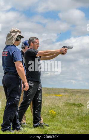 Des instructeurs enseignent à l'homme comment tenir et tirer le pistolet sur le tir américain en direct, fort Collins USA Banque D'Images