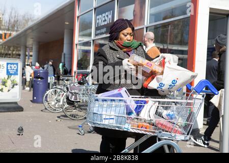 Tesco Superstore, Hackney Central, Londres, Royaume-Uni. 22 mars 2020. La nouvelle politique de Tesco permet aux employés et aux personnes de plus de 65 ans d'entrer dans la boutique en premier. À l'entrée, une pièce d'identité est vérifiée pour ceux qui prétendent être un travailleur clé.les gens commencent à faire la queue avant l'ouverture en raison de la propagation du coronavirus. Les travailleurs de Tesco laissent entrer dans le magasin seulement de petits groupes pour éviter de créer une foule et rester distanciation sociale. Crédit: Marcin Nowak/Alay Live News Banque D'Images