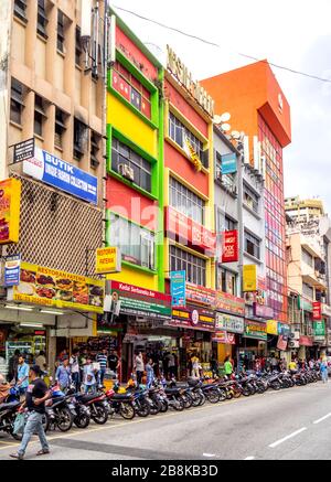 Rangée de magasins de motos garées et d'Indiens marchant le long de Jalan Tun Tan Siew Sin Chinatown Kuala Lumpur Malaisie. Banque D'Images