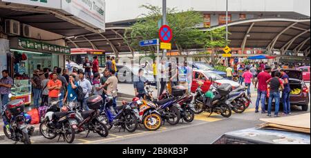 Des hommes indiens se rassemblent et se loitent devant le dépôt d'autobus dans le quartier chinois de Kuala Lumpur en Malaisie. Banque D'Images