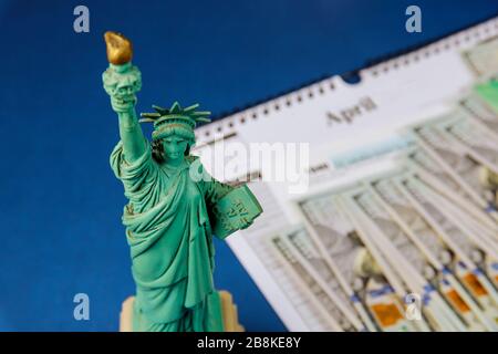 Statue Liberty dans la période fiscale aux États-Unis avec 1040 formulaire d'impôt américain, argent et calendrier US dollars de déclaration d'impôt Banque D'Images