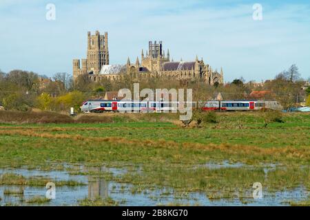 Un grand Anglia Stadler Flirt classe 755 passe sous la cathédrale d'Ely tout en travaillant un service de voyageurs en direction du sud le 21 mars 2020. Banque D'Images