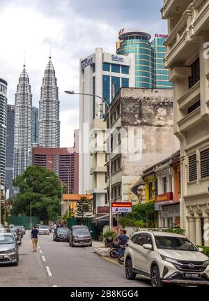 Circulation et piétons sur la rue Jalan Yap Ah Shak et Petronas Twin Towers en arrière-plan Kuala Lumpur Malaisie. Banque D'Images