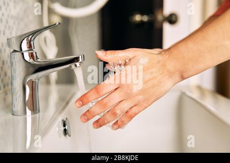 La fille se lave les mains avec du savon pour empêcher le coronavirus. Banque D'Images