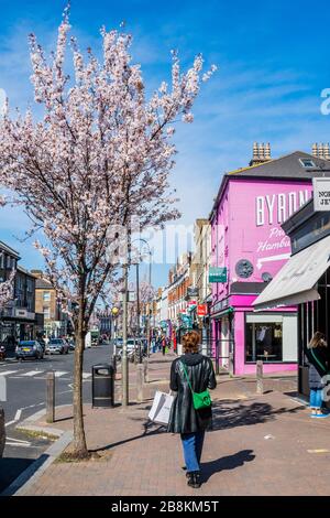 Londres, Royaume-Uni. 22 mars 2020. La vie se poursuit pour la fête des mères, sous le ciel bleu et avec les arbres fleuris, sur Northcote Road. Cependant, les restaurants normalement occupés sont maintenant fermés - Anti Coronavirus (Covid 19) éclosion à Londres. Crédit: Guy Bell/Alay Live News Banque D'Images