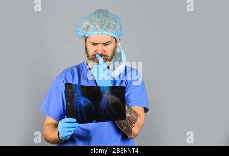 Fracture et dommages osseux. Le médecin examine l'instantané radiographique du poignet. Le chirurgien estime les dommages. Urgence hospitalière. Le médecin compare les résultats. Rayonnement de rayons X. Le médecin possède des images d'os. Banque D'Images