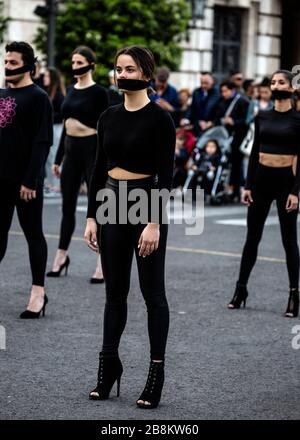 Troupe de danse vêtue de masques de visage noir portant sur leurs bouches, International Women's Day 2020, Valencia, Espagne. Banque D'Images