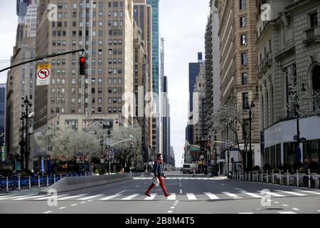 New York, États-Unis. 22 mars 2020. Un homme porte un masque de protection lorsqu'il traverse un vide de piétons et de la circulation de la 6ème Avenue à New York le dimanche 22 mars 2020. Gov de l'État de New York. Andrew Cuomo a déclaré que le nombre de décès liés au coronavirus dans l'État est maintenant de 114 et parmi les 15 168 cas positifs, 9 045 ont été enregistrés dans la ville de New York. Photo de John Angelillo/UPI crédit: UPI/Alay Live News Banque D'Images