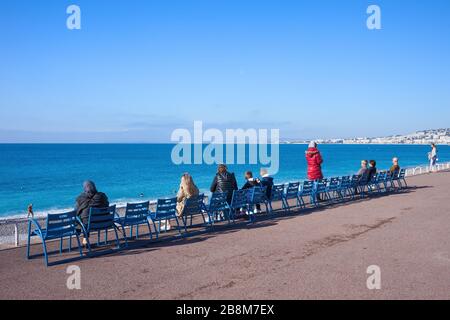 Nice, France - 16 avril 2018 : les gens se détendent sur la Promenade des Anglais sur la Côte d'Azur assis sur des chaises face à la mer Banque D'Images