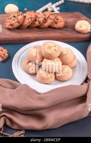 Biscuits au beurre dans un plateau blanc et biscuits aux flocons d'avoine sur un plateau de woode Banque D'Images